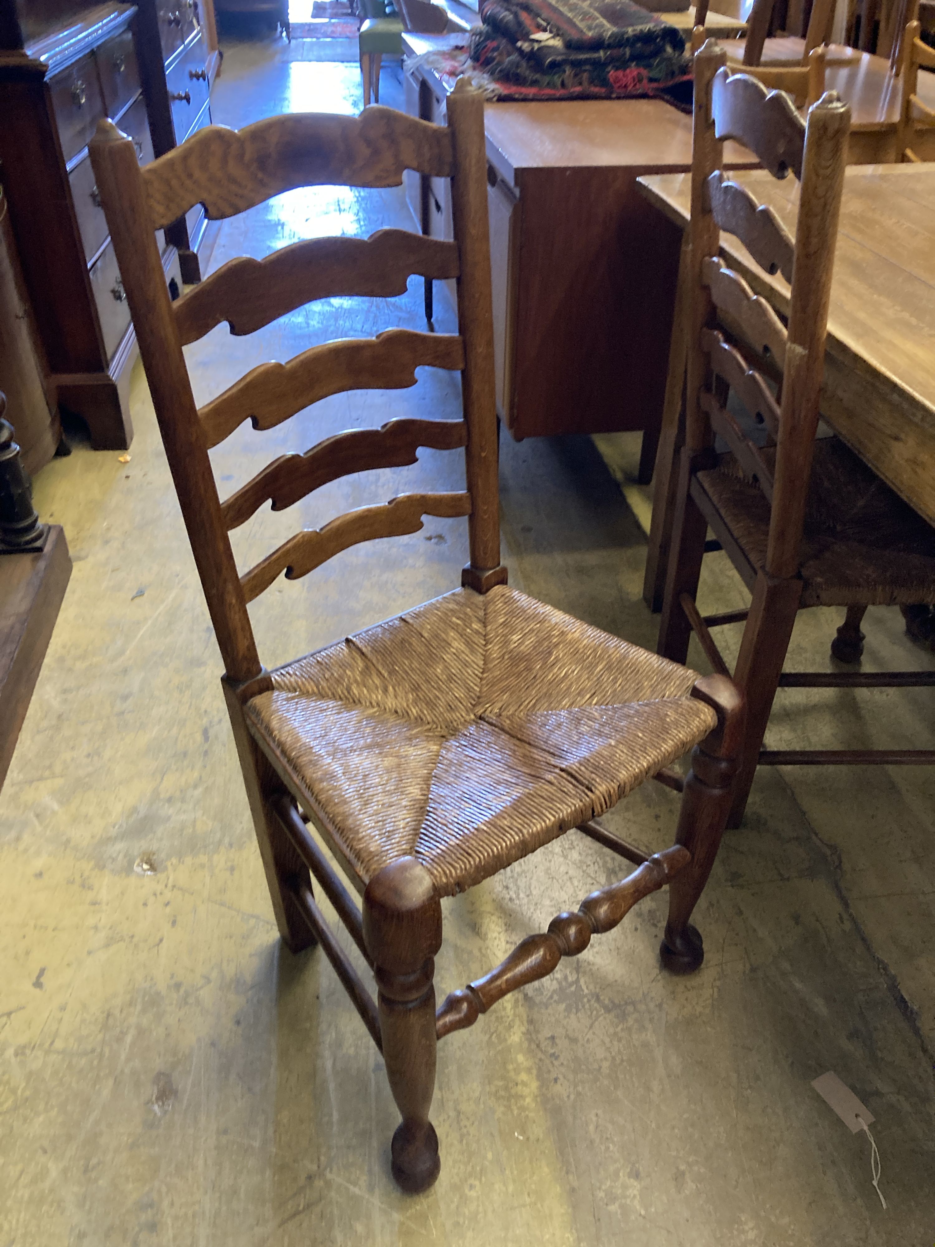 A set of six ladderback dining chairs with rush seats, two having arms